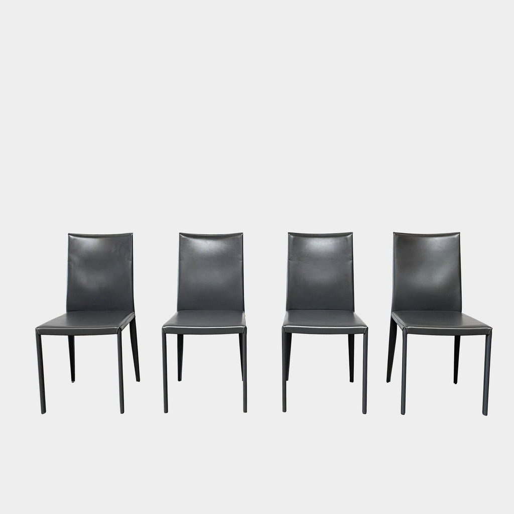 Four Frag Bella Dining Chairs in Dark Grey Leather with metal legs, arranged in a straight line against a plain white background.