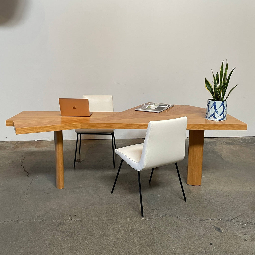 Modern Cassina Ventaglio Table inspired by Charlotte Perriand's functional ingenuity, with an asymmetrical, angular top and four cylindrical legs, isolated on a white background.