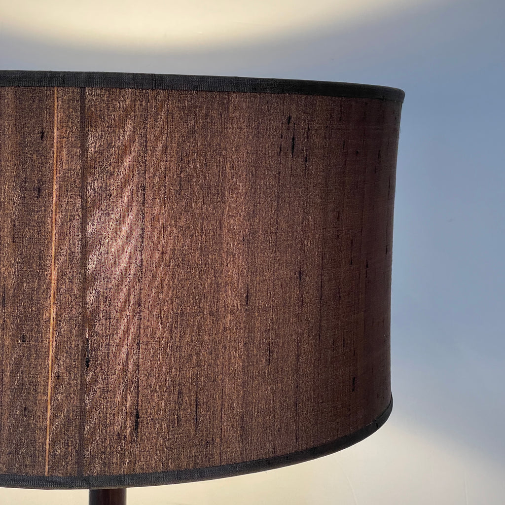 A Penta Wood Table Light with a brown shade on top.
