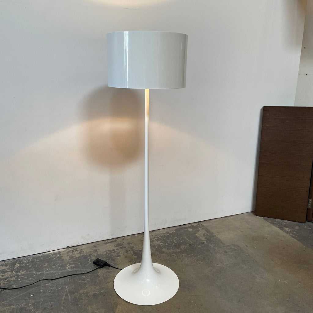 A modern Flos Spun Floor Light with a spun aluminum frame and a white base and shade.