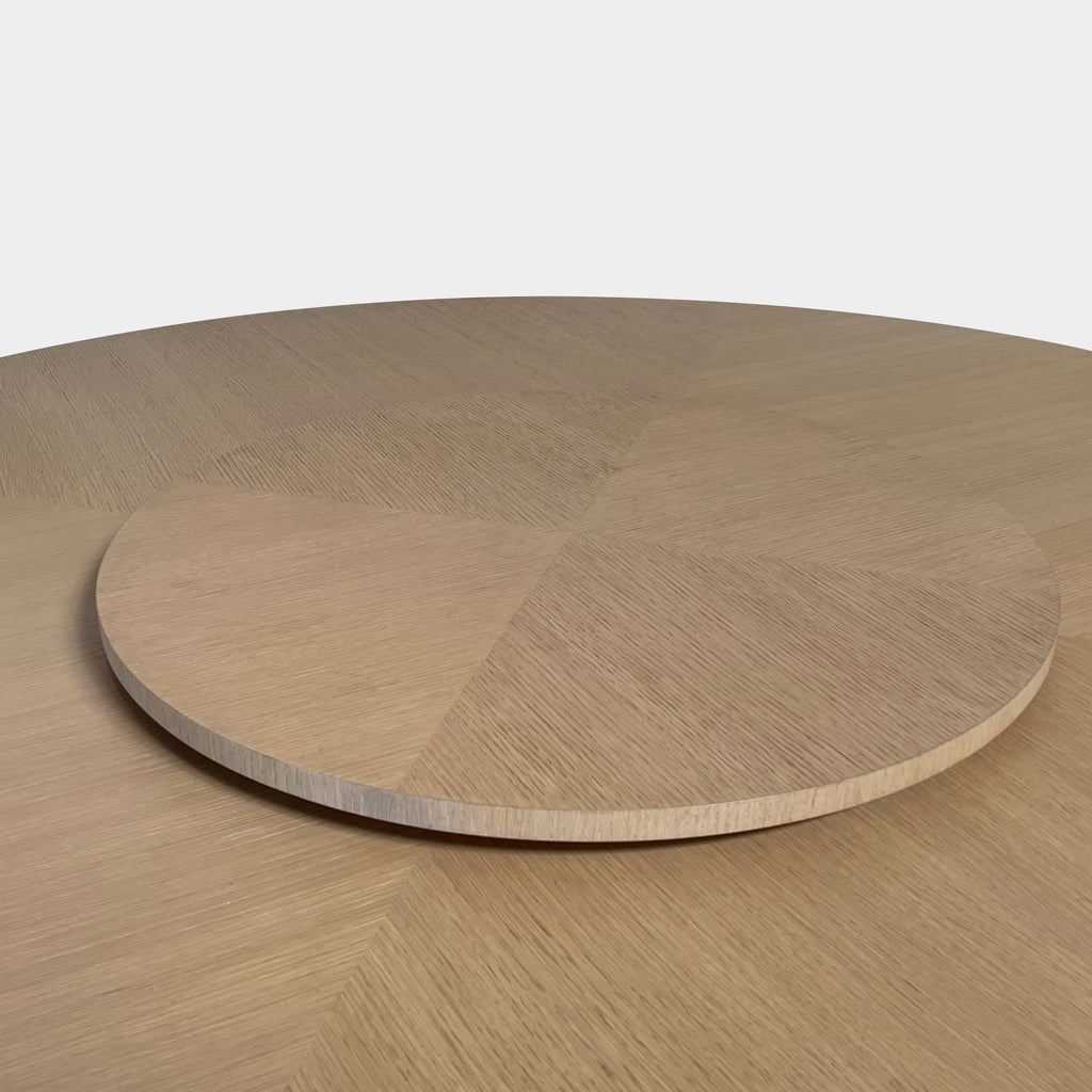 Round Maxalto Xilos dining table with rotating tray centerpiece on a crossed leg base, isolated on a white background.