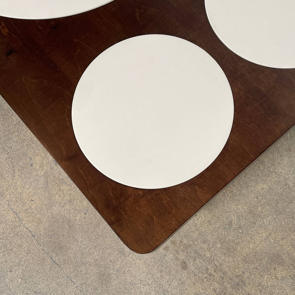 Giorgetti Camaleo coffee table with a dark finish and three white oval insets on metal legs.
