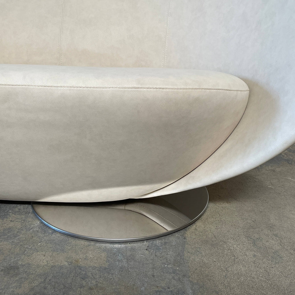 A modern beige La Cividina Mon Coeur Sofa with a curved backrest and metallic legs isolated on a white background.