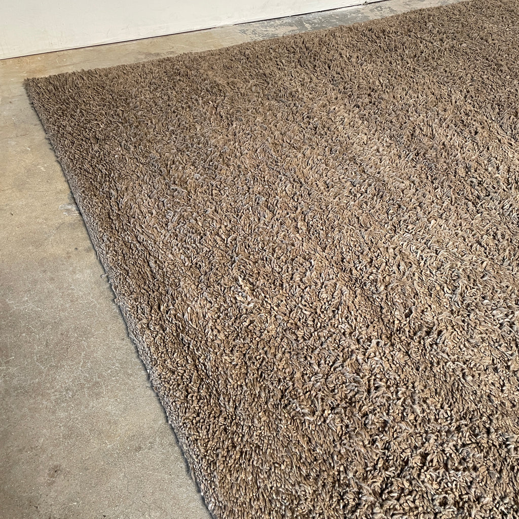 Close-up of a textured, Delinear Anemone Warm Grey 8'X10' Shag Rug made of Himalayan wool in a neutral color.