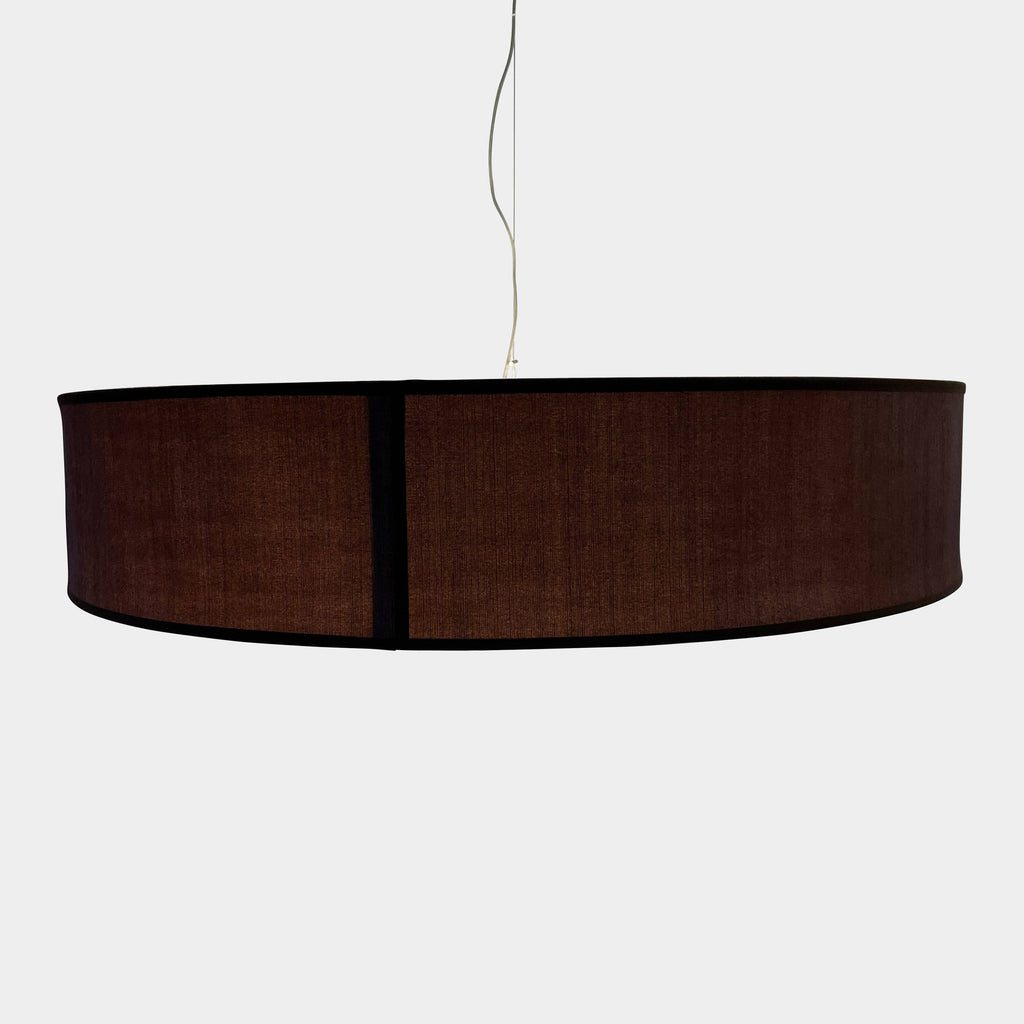 A large black Penta Low Cylinder pendant light hanging from a low ceiling.