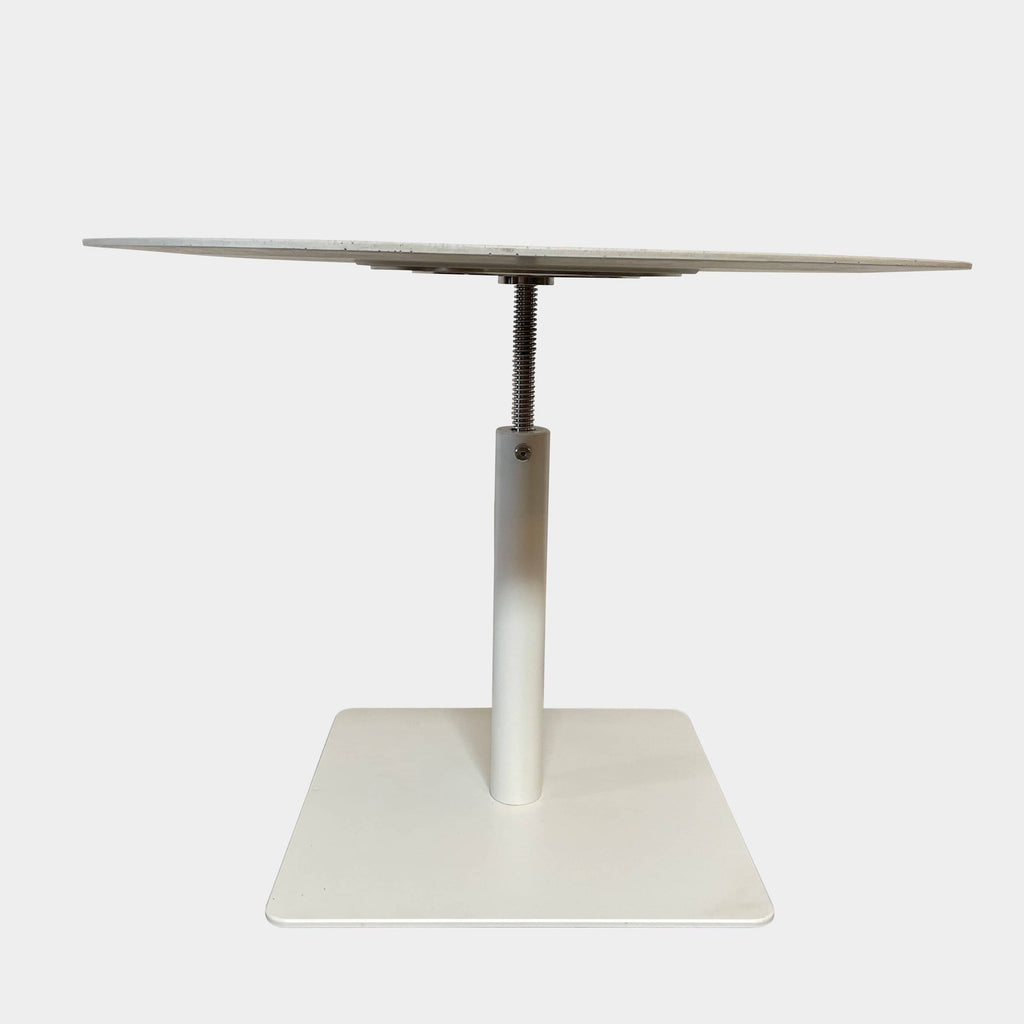 An adjustable height Giro Outdoor Table with a white base on a white background, made by Paola Lenti.