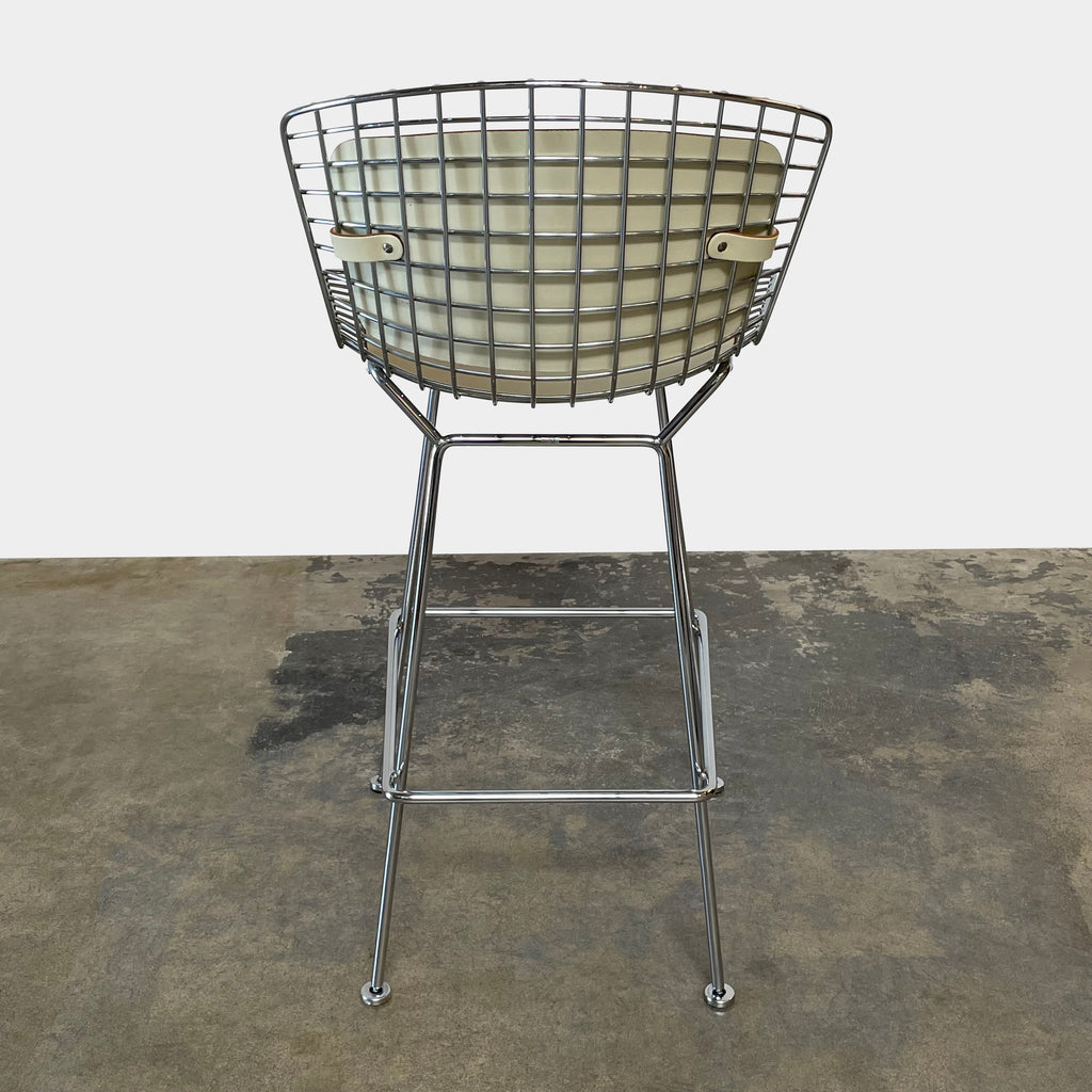 Two modern Knoll Bertoia bar height stools with beige seats and open grid backs, crafted from welded steel rods, on a white background.
