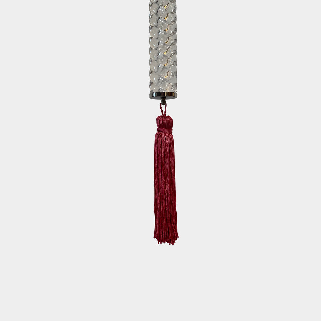 A Baccarat Torch Ceiling Lamp with a red tassel hanging from it.