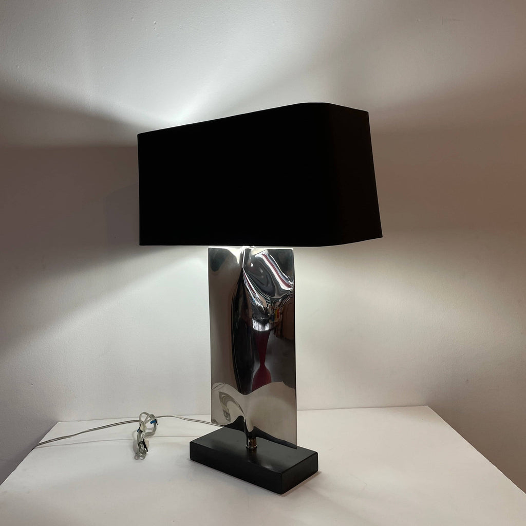 A Porta Romana Waterfall Table Lamp with a metallic base and a rectangular black fabric shade, designed by Porta Romana, isolated on a white background.