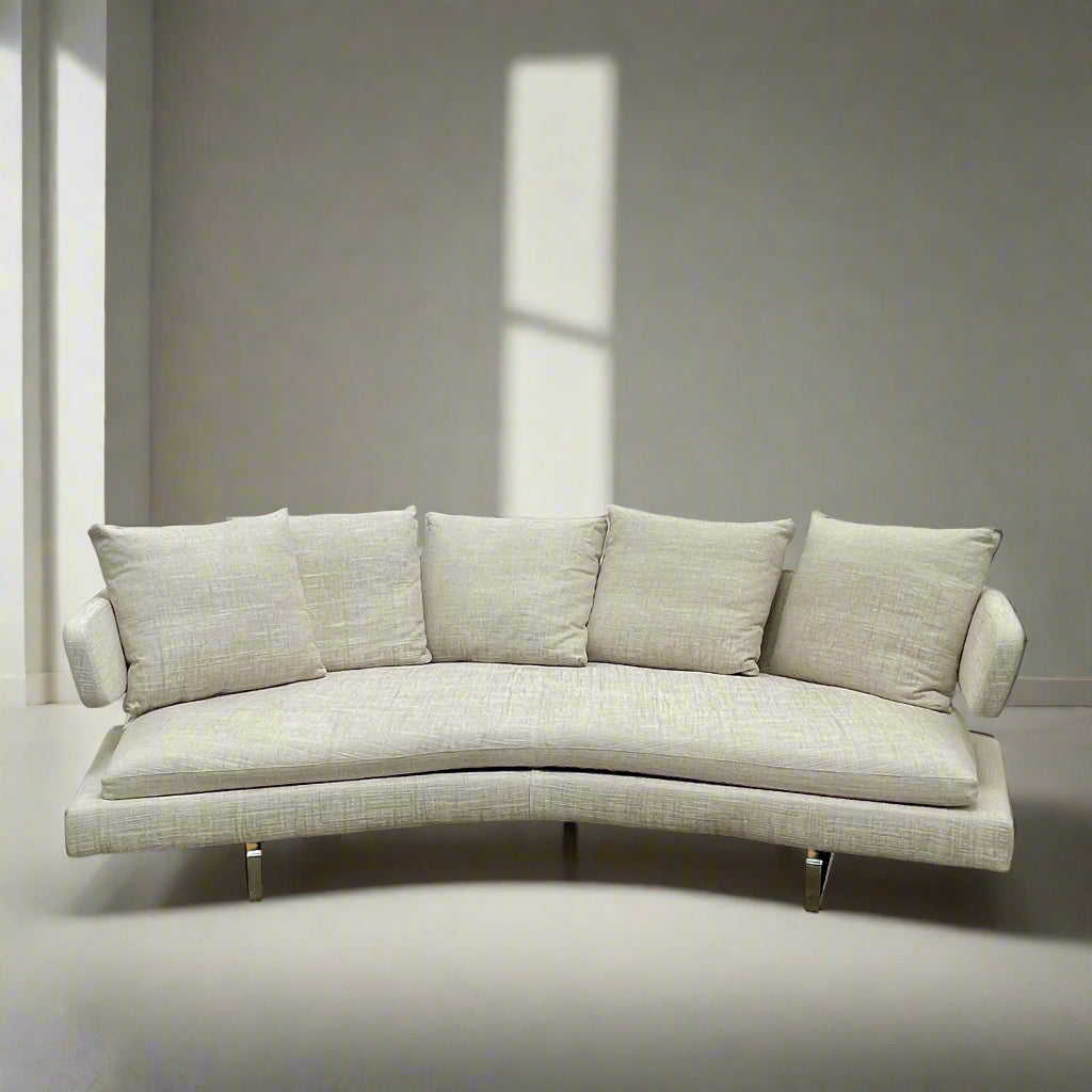 Experience the B&B Italia Arne Sofa, a modern off-white masterpiece with five plush cushions and cylindrical armrests. Designed by Antonio Citterio, it features sleek metal legs set against a crisp background.