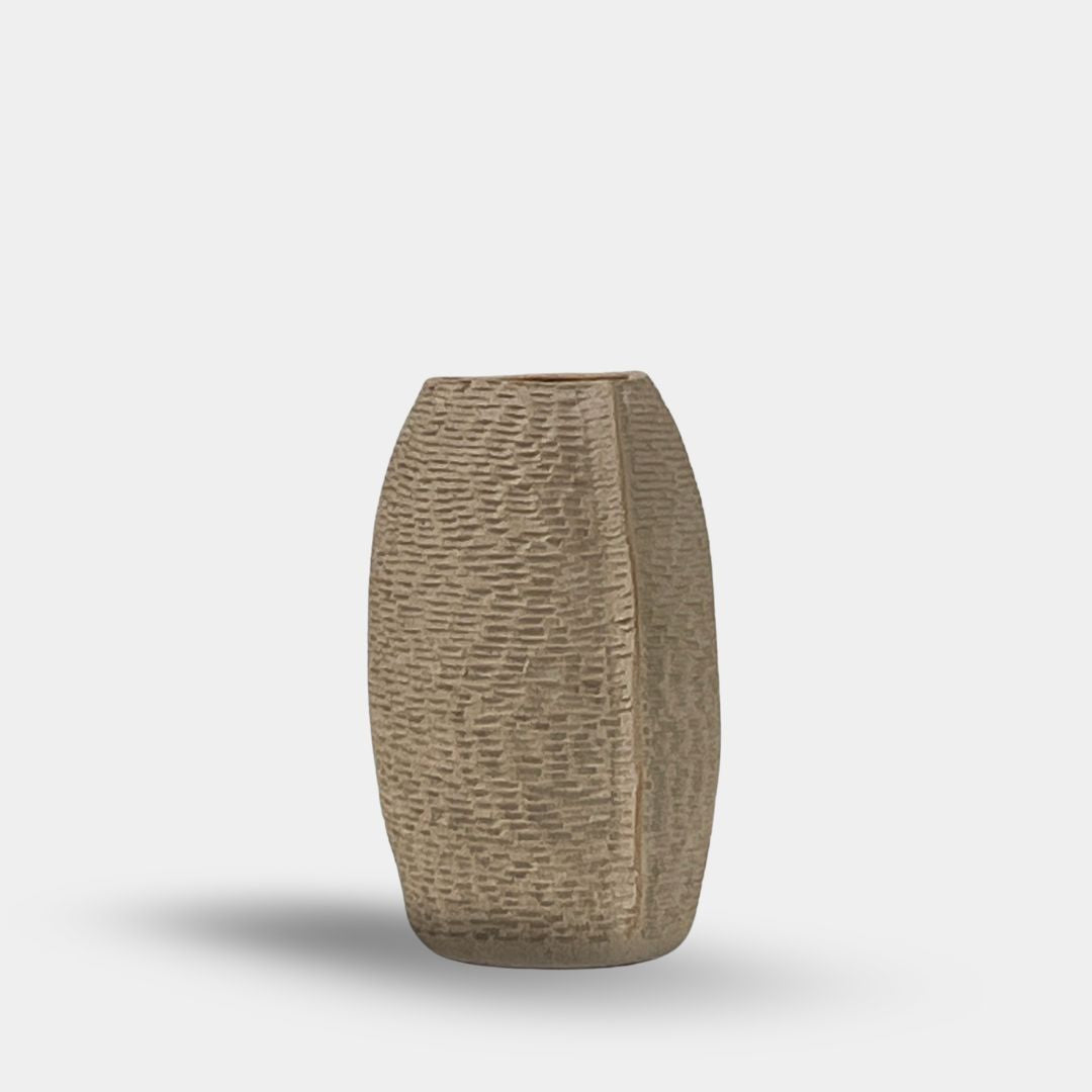 The Sofi Ceramic Pleated Light Clay Vase from Sofi Ceramics stands elegantly on a plain white background, featuring a tall cylindrical shape with textured pleats and a subtle vertical seam, echoing the rich artistry of African cultures.