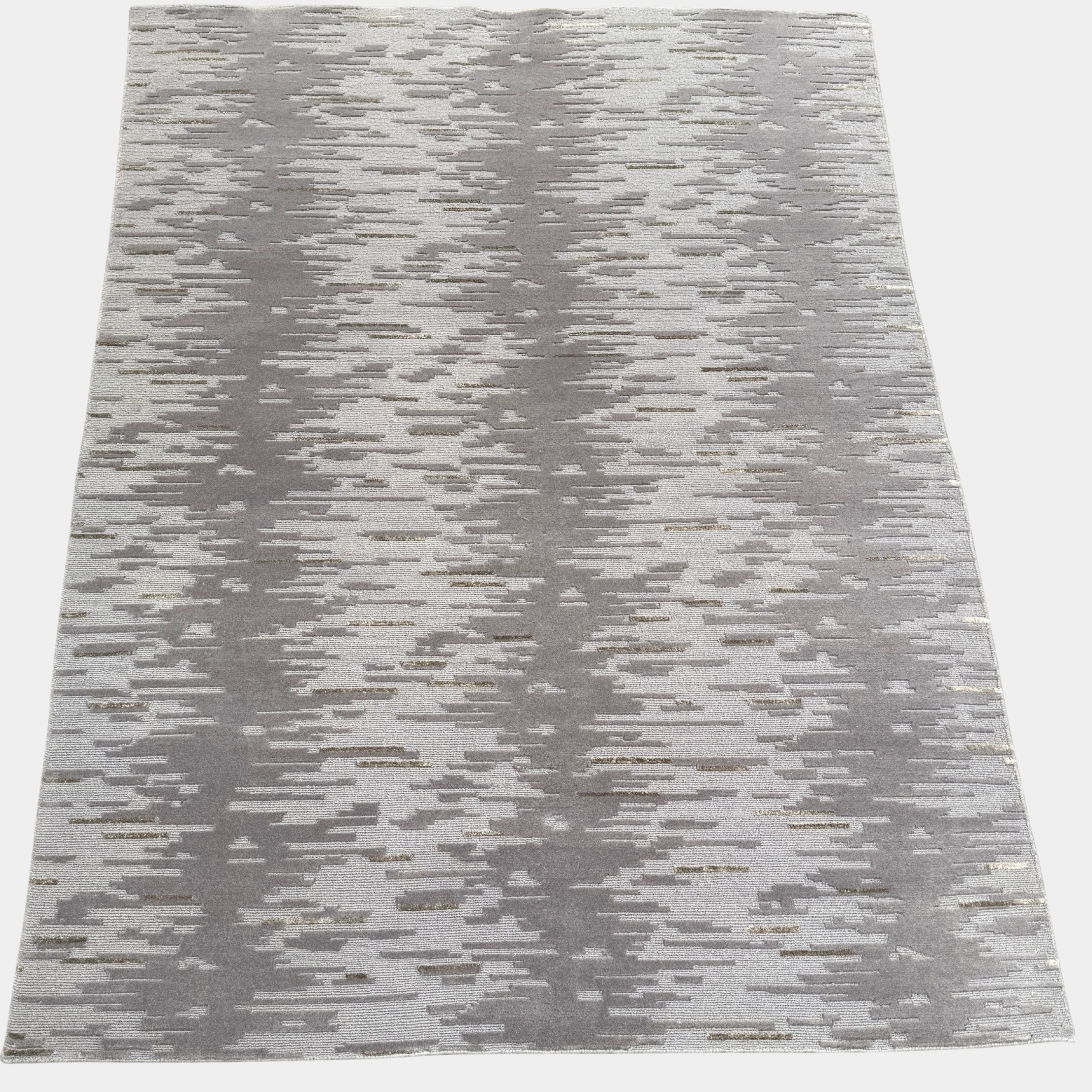 A close-up of the Kvadrat Multi-pile Wool and Silk Rug by Kvadrat, featuring an abstract linear pattern in light and dark gray wool and silk, displayed on a white background.