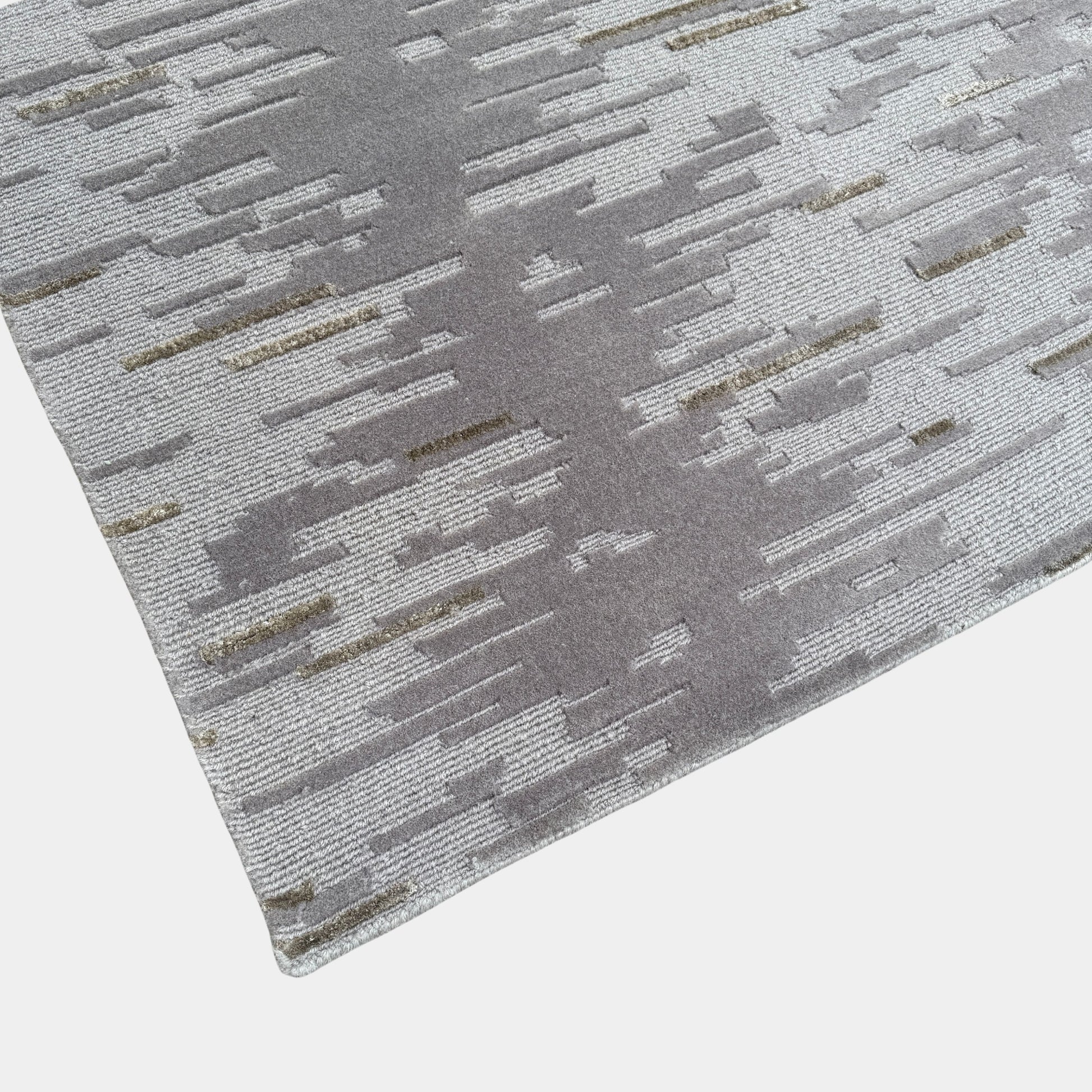A close-up of the Kvadrat Multi-pile Wool and Silk Rug by Kvadrat, featuring an abstract linear pattern in light and dark gray wool and silk, displayed on a white background.