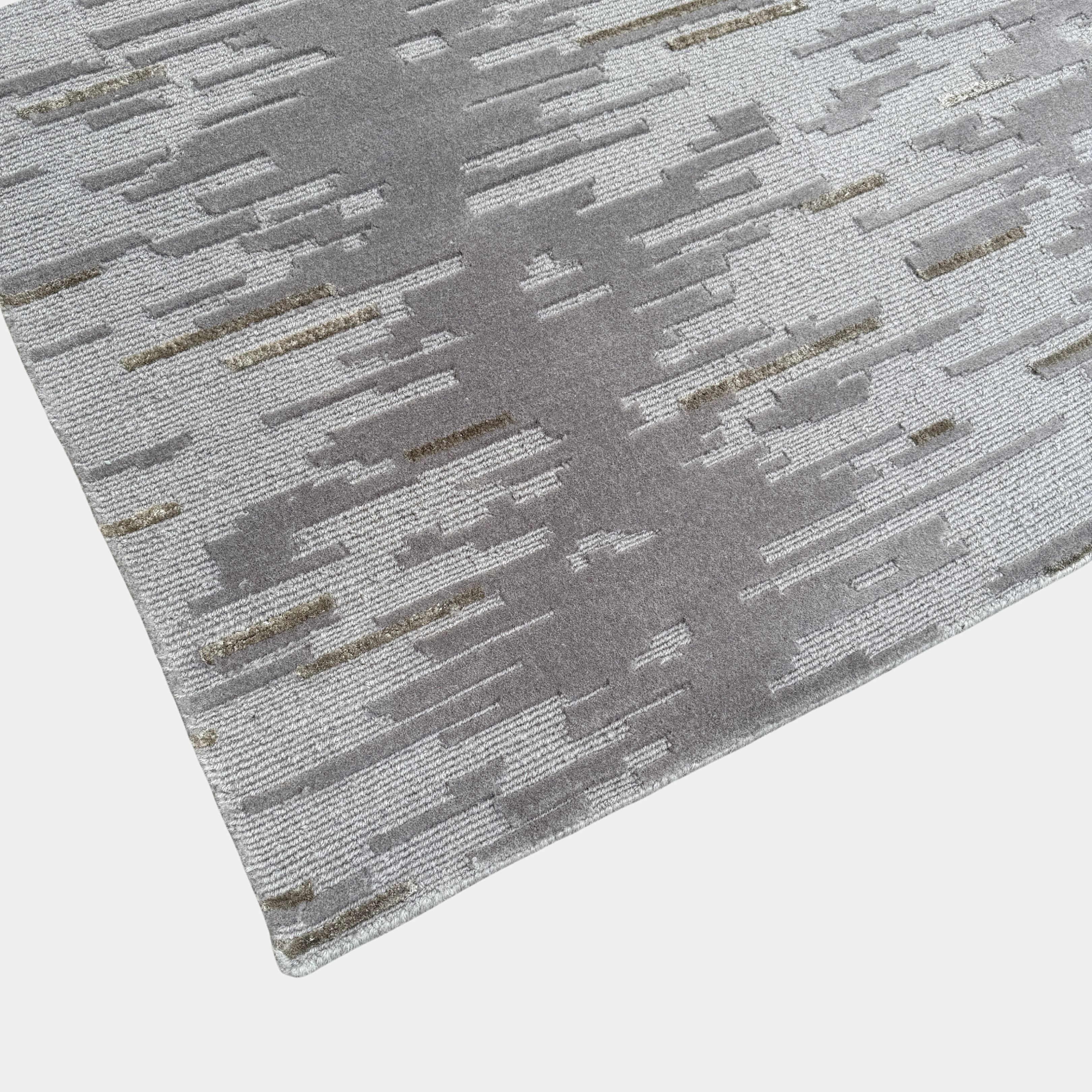 A close-up of the Kvadrat Multi-pile Wool and Silk Rug by Kvadrat, featuring an abstract linear pattern in light and dark gray wool and silk, displayed on a white background.
