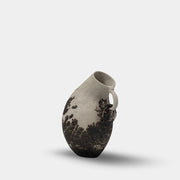 The Sofi Ceramic Curved Jug by Sofi Ceramics is a handbuilt white and black ceramic vase with an irregular shape, small handle, and abstract dark patterns reminiscent of sculptured vessels.