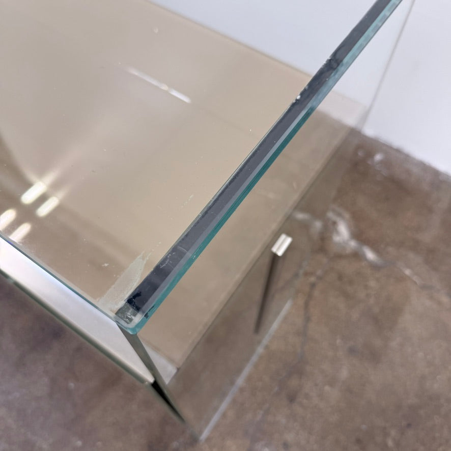 A long Gallotti & Radice Air Console Table featuring a clear glass frame and four opaque taupe storage cabinets.