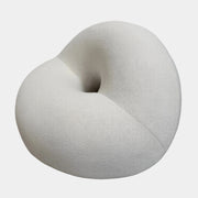 The Objects of Common Interest Tube Chair by Objects of Common Interest is a modern, light grey lounge chair with a donut-shaped design, rounded form, and central indentation, shown against a plain white background.