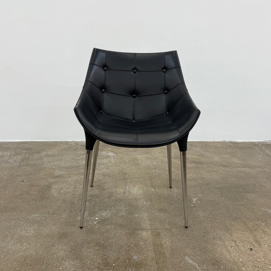 The Cassina Passion Side Chair by Cassina is a modern black upholstered chair with a curved backrest, button detailing, and four sleek metal legs inspired by the Passion design.