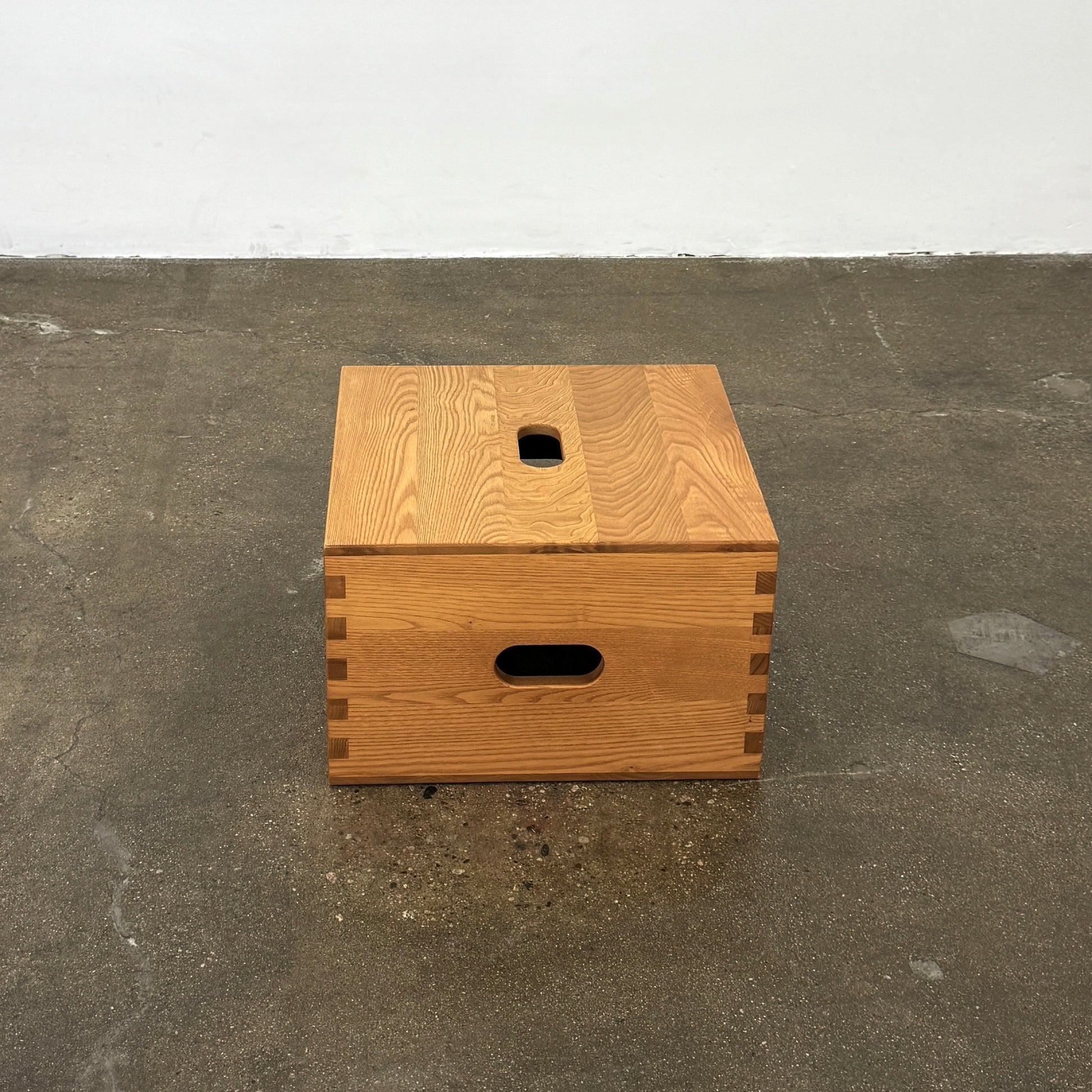 Cassina's LC14 Tabouret Maison du Brésil Tabouret Cabanon, a rectangular wooden box with dovetail joints and three oval handles, is shown against a plain white background.