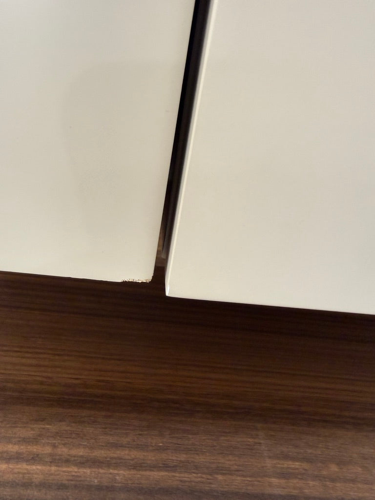 The Molteni & C Fortepiano Wall-mounted Desk System features a long wooden shelf, beige storage cabinets, and drawers for a sleek, modern look against a white wall.