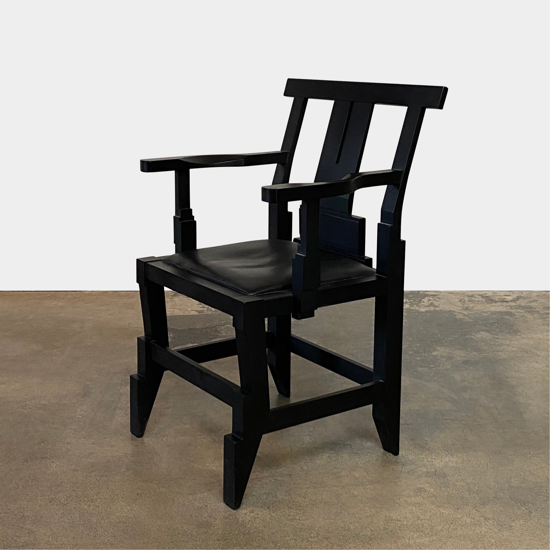 A rare vintage Solitar armchair by John Kandell, crafted in black wood, showcases an angular, geometric design that evokes the Memphis Design movement, displayed against a plain background.