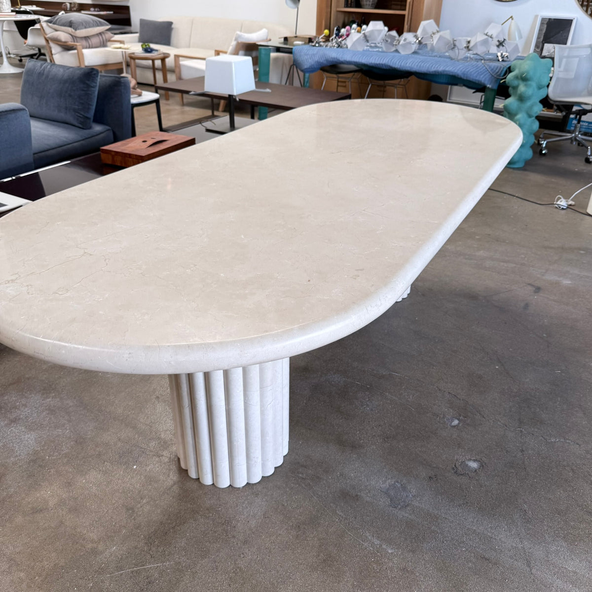 Form LA Fluta Oval Dining Table in Crema Marfil with a smooth top and two fluted cylindrical pedestals inspired by Roman architecture.
