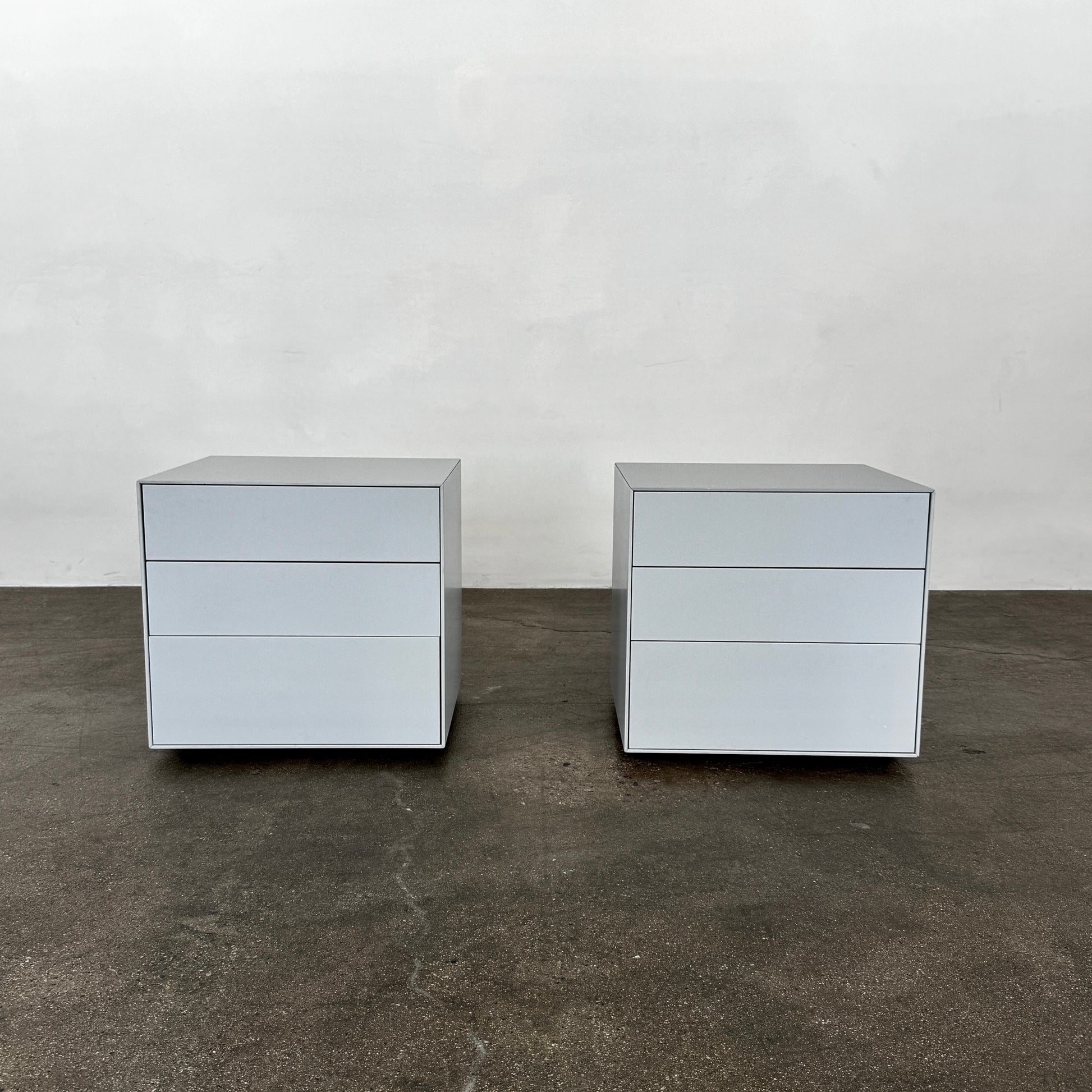 The Treku Lauki collection Side Table (2) by Treku, a gray rectangular side table with three drawers and a minimalist design, is shown against a plain white background.