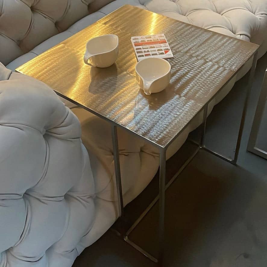 The Minotti Leger Side Table, by Minotti, features a metallic accent with its metal frame, creating a clean and minimal design against a white background.