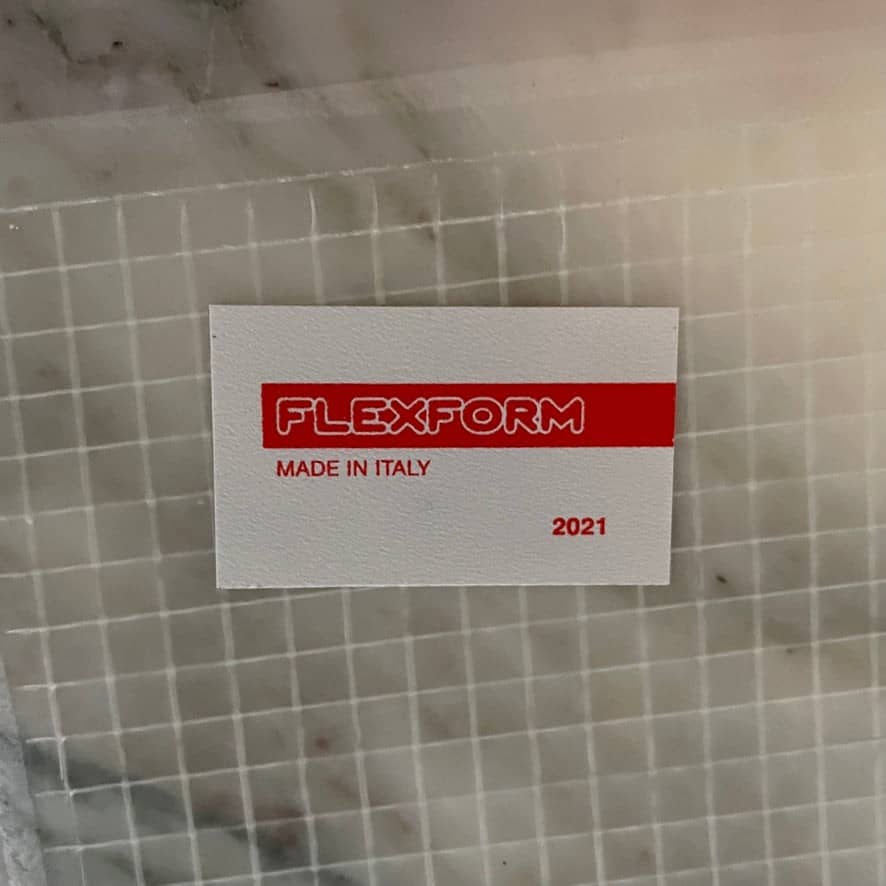 A Flexform Fly Marble Coffee Table with black legs on a white background.