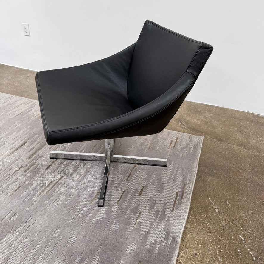 A close-up of the Kvadrat Multi-pile Wool and Silk Rug by Kvadrat, featuring an abstract linear pattern in light and dark gray wool and silk, displayed on a white background.