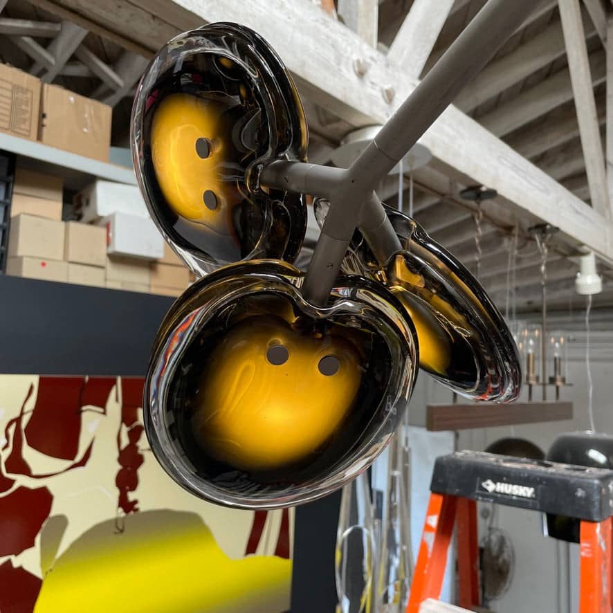 The Bocci Armature Chandelier T16.17aA1 by Bocci features multiple black branches with round, illuminated bulbs extending from a central base, offering a modern ceiling light fixture design inspired by contemporary aesthetics.