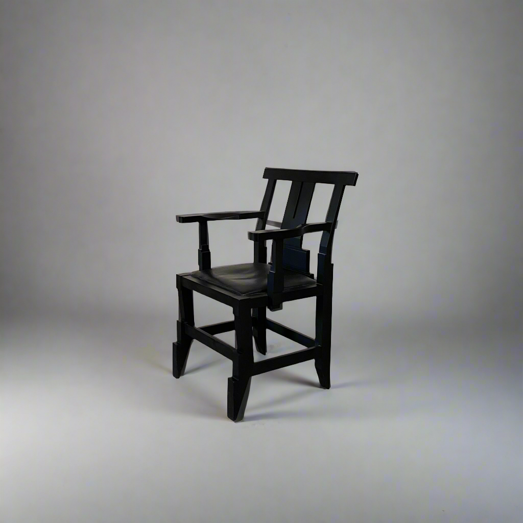 A rare vintage Solitar armchair by John Kandell, crafted in black wood, showcases an angular, geometric design that evokes the Memphis Design movement, displayed against a plain background.