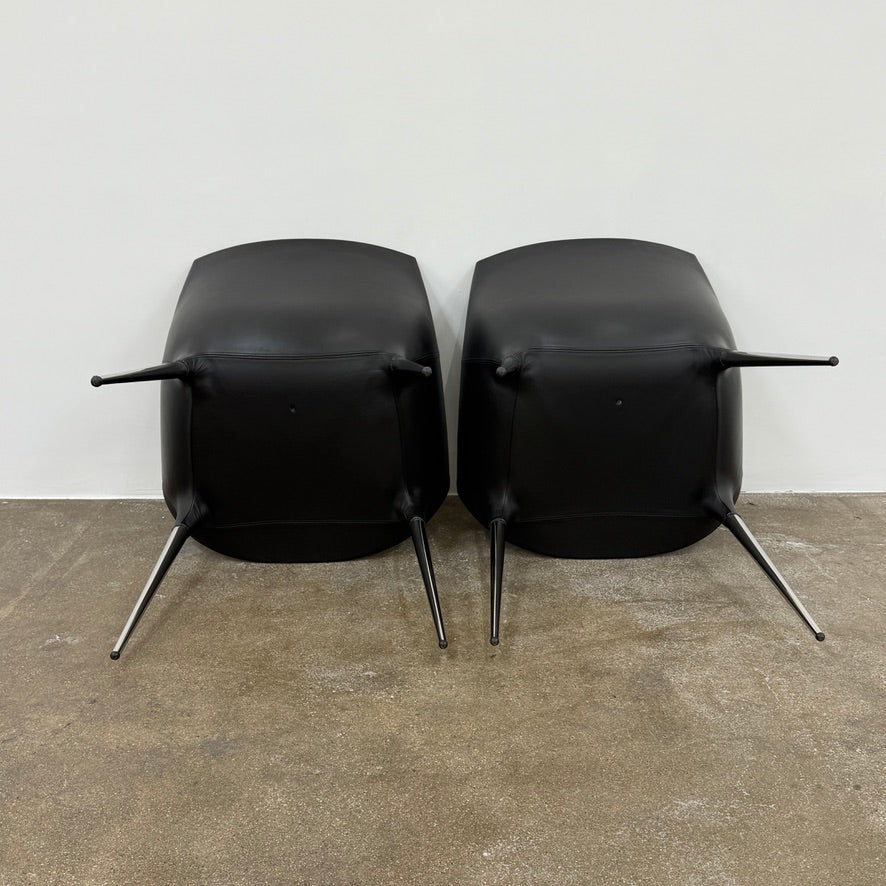 The Cassina Passion Side Chair by Cassina is a modern black upholstered chair with a curved backrest, button detailing, and four sleek metal legs inspired by the Passion design.