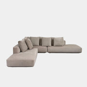 The Zanotta Pianoalto sectional by Modern Resale, in light beige with five back cushions, is placed on a bare concrete floor against a plain white wall.