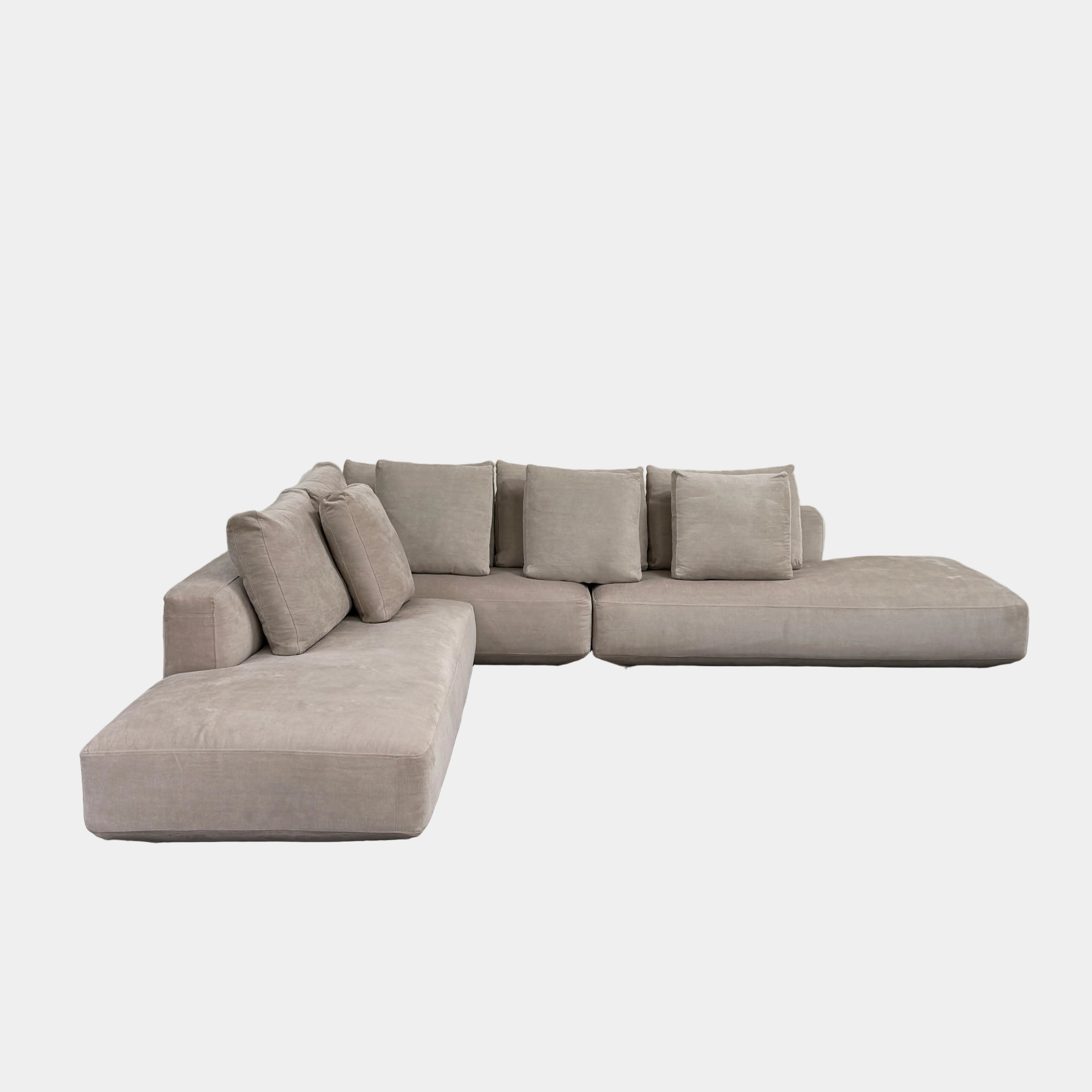 The Zanotta Pianoalto sectional by Modern Resale, in light beige with five back cushions, is placed on a bare concrete floor against a plain white wall.