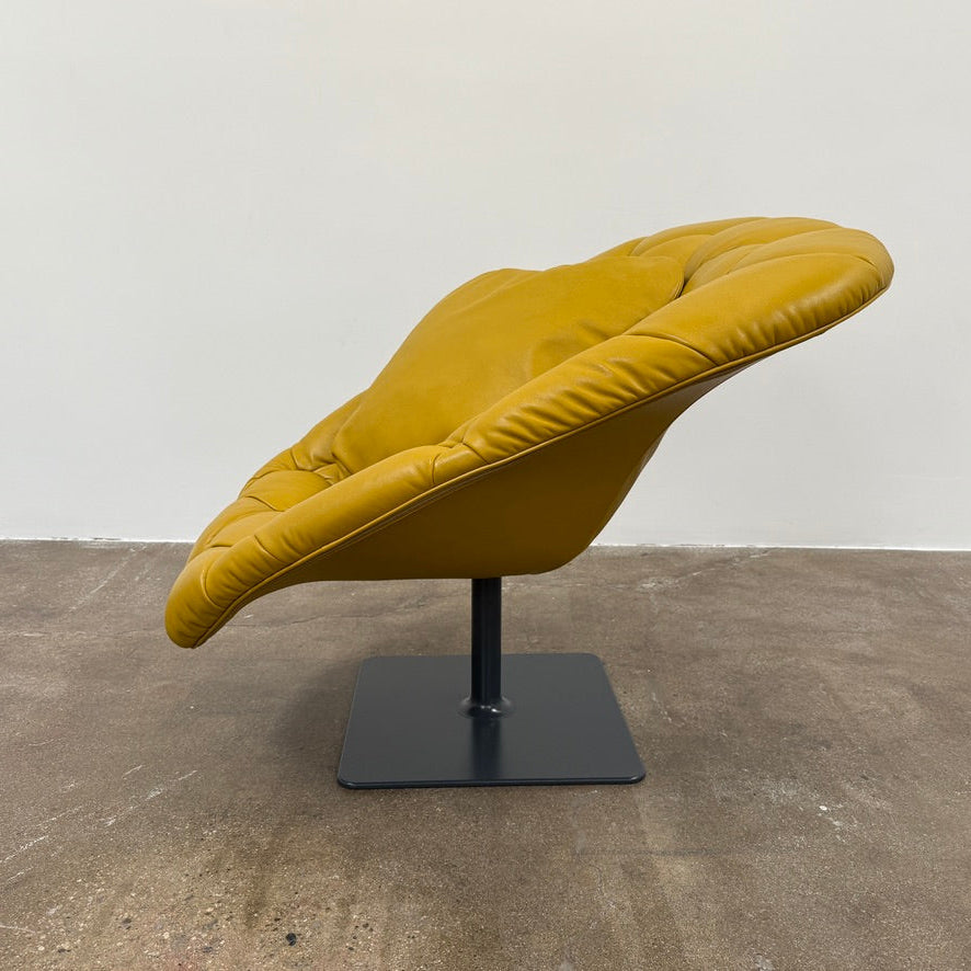 The Moroso Bohemian Low Armchair by Moroso features mustard yellow tufted leather upholstery, a matching cushion, and a black metal pedestal base, shown against a plain white background.