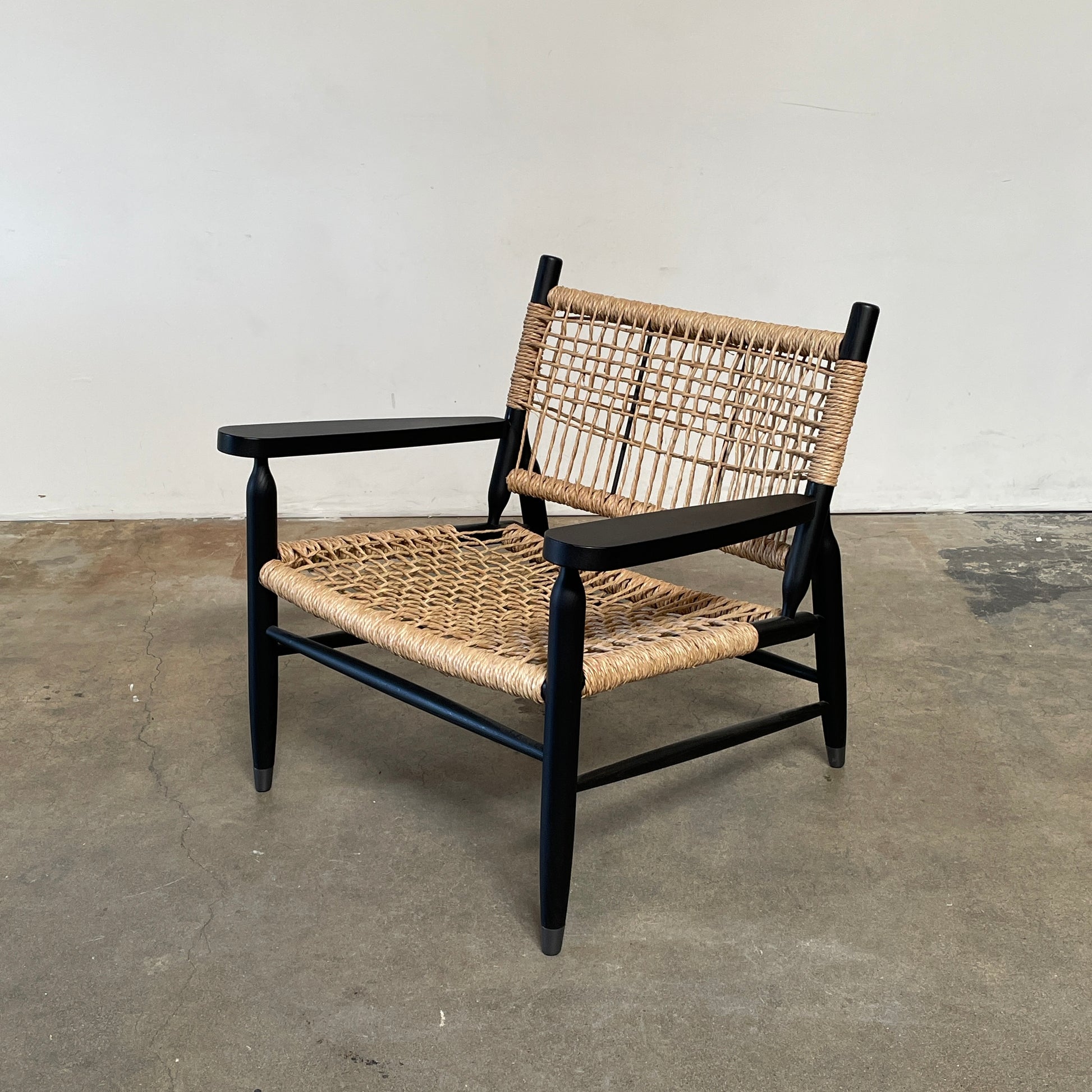 Two hand-crafted Flexform Tessa Lounge Chairs with black frames and neutral-tone cushions on a white background.