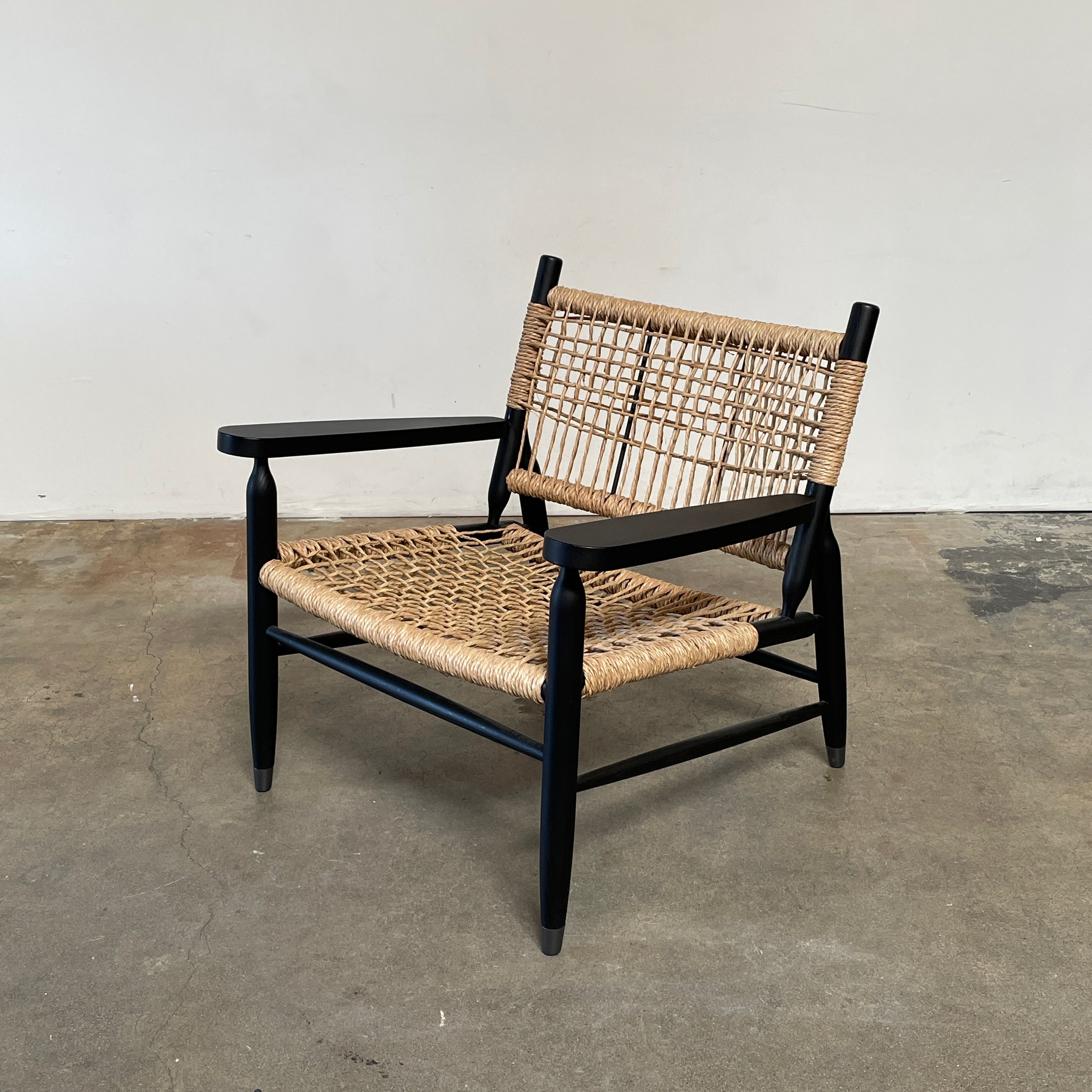 Two hand-crafted Flexform Tessa Lounge Chairs with black frames and neutral-tone cushions on a white background.