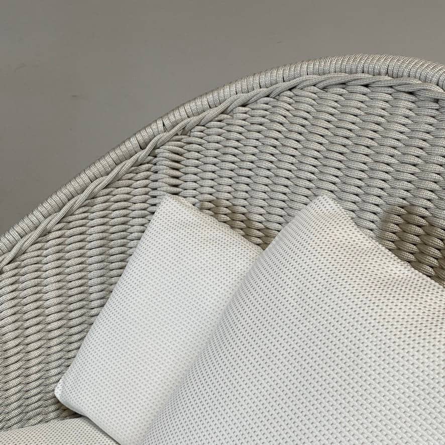 A white Paola Lenti Nido Lounge Chair with pillows.