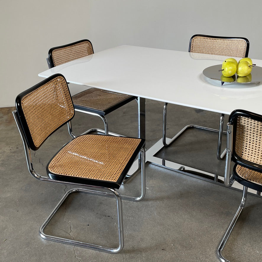 The Vintage Marcel Breuers Cesca Dining Chair showcases a chrome tubular steel frame with black edges and a woven cane seat and backrest, displayed against a plain white background.