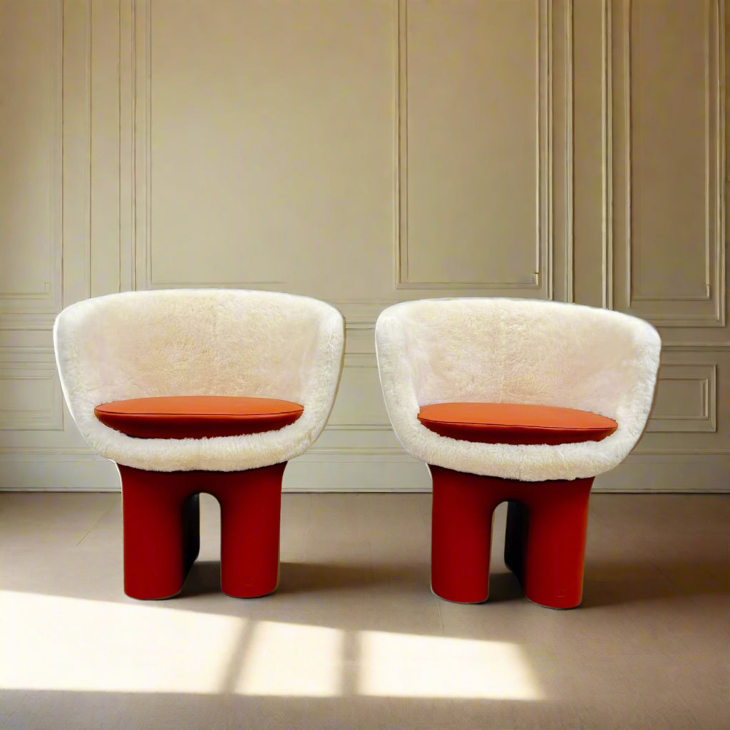 The Louis Vuitton Dolls Fur by Raw Edges is a modern chair with a curved white fluffy leather and fur seat, two short cylindrical brown legs, and a matching brown base, designed by Louis Vuitton and set against a plain background.