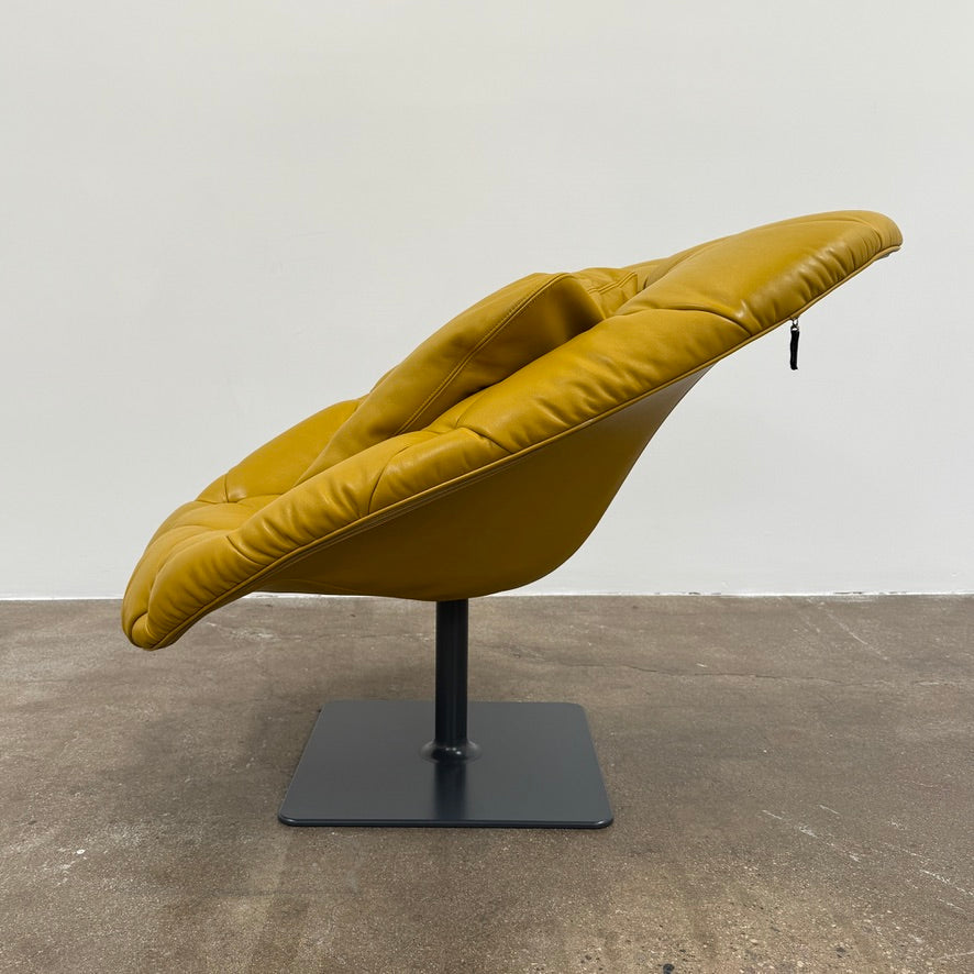 The Moroso Bohemian Low Armchair by Moroso features mustard yellow tufted leather upholstery, a matching cushion, and a black metal pedestal base, shown against a plain white background.