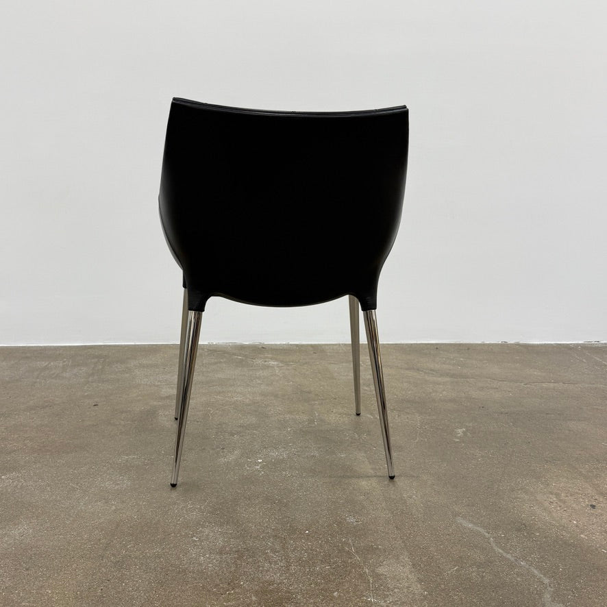 The Cassina Passion Side Chair by Cassina is a modern black upholstered chair with a curved backrest, button detailing, and four sleek metal legs inspired by the Passion design.