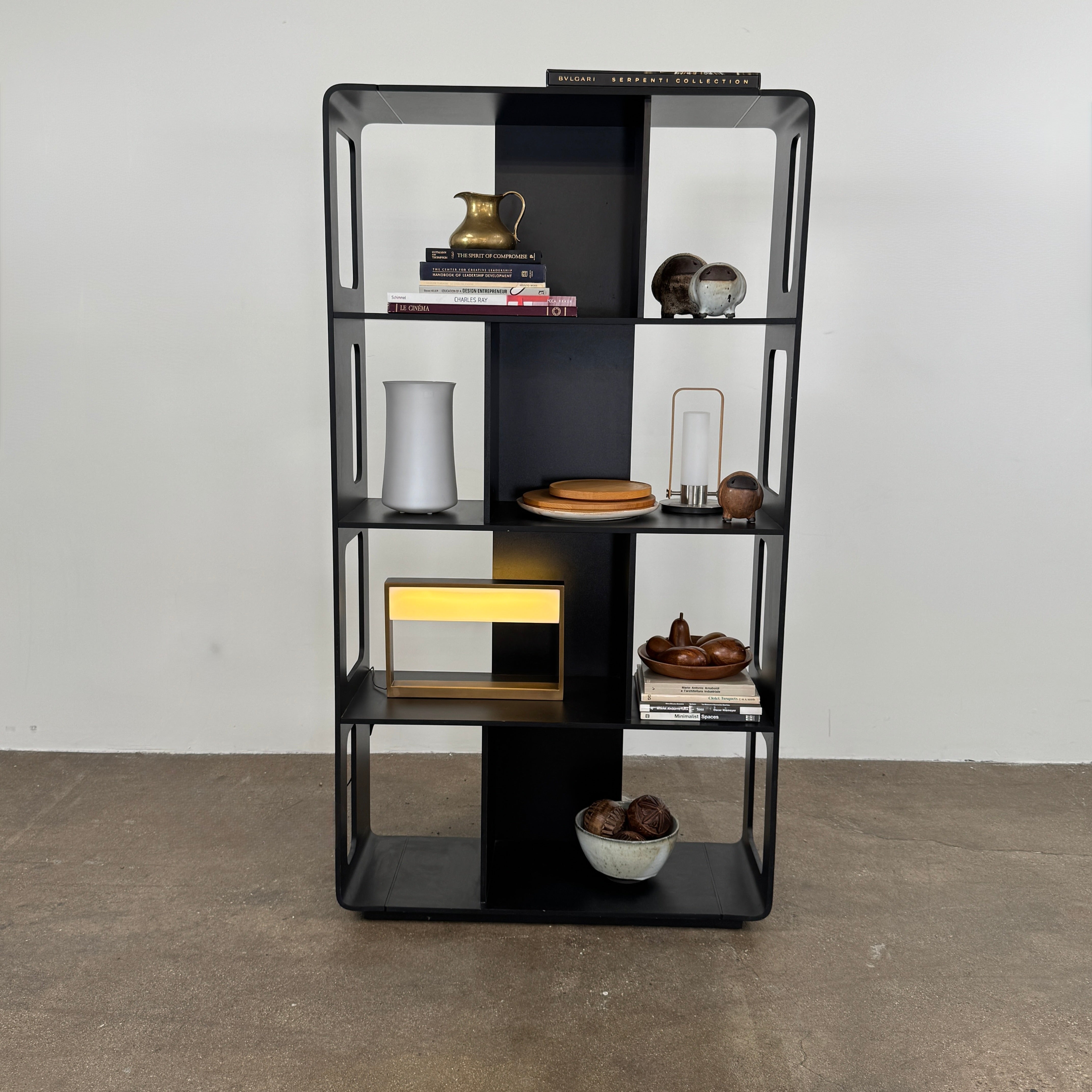 The B&B Italia Arne Bookcase Black Oak by B&B Italia is a modern open-frame bookshelf with five shelves and rectangular side cutouts, inspired by the Arne design, shown against a plain white background.