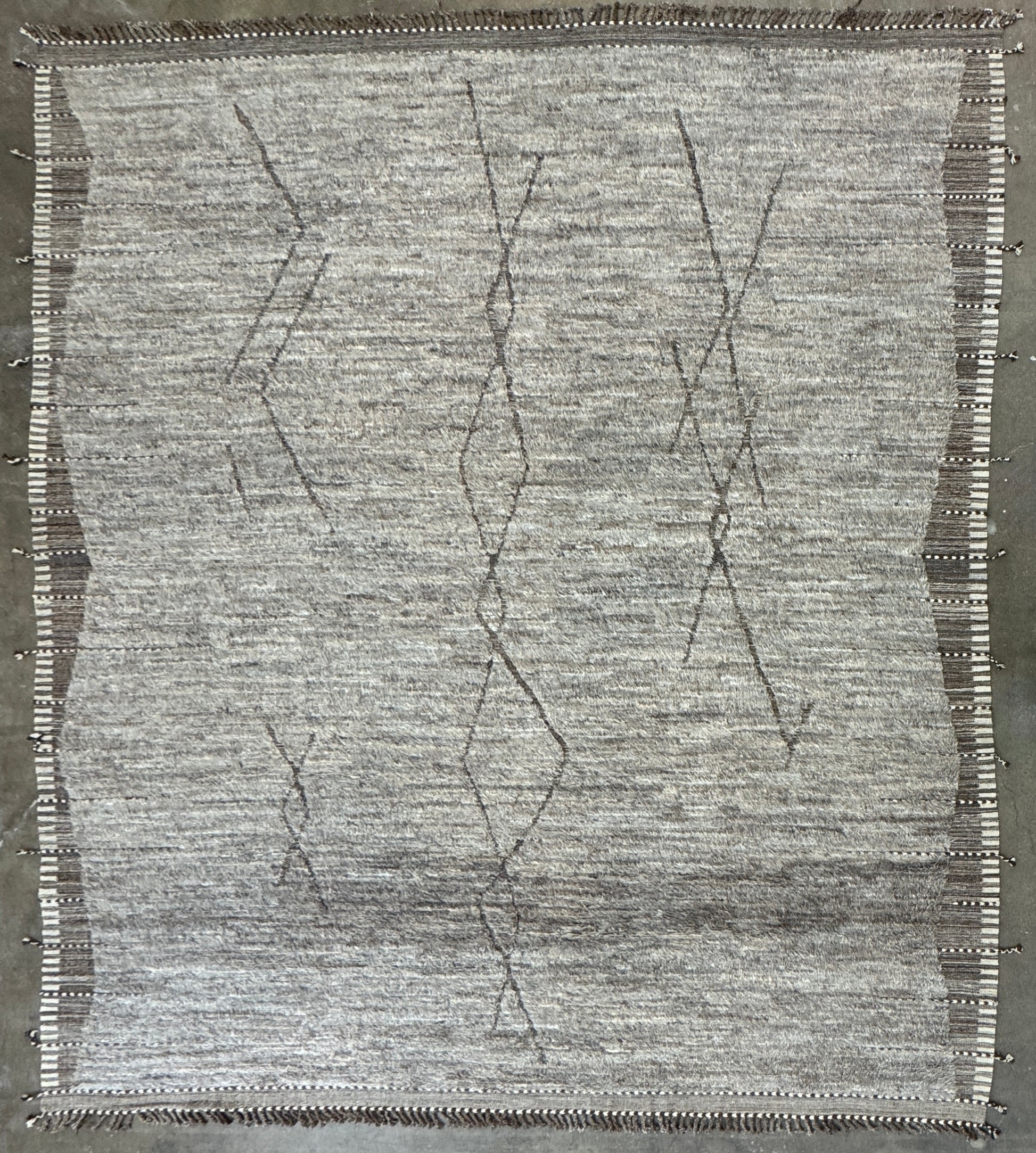 The Mehraban Gilavar Rug (13' x 15'.5") by Mehraban features handwoven, textured neutral tones, fringe tassels on the edges, and striped and patterned designs.