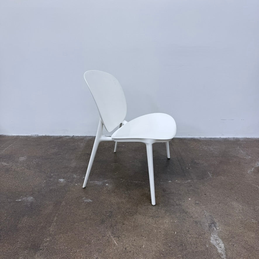 A white Kartell Be Bop lounge chair with a rounded backrest, tapered legs, and a weatherproof design for indoor or outdoor seating.