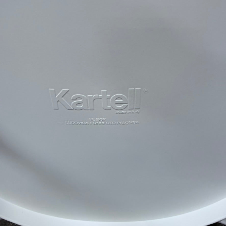 A white Kartell Be Bop lounge chair with a rounded backrest, tapered legs, and a weatherproof design for indoor or outdoor seating.