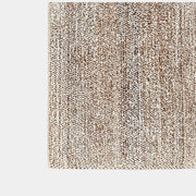 Close-up of the textured beige and brown woven surface of the ABC Carpet and Home 8'x10' rug by Modern Resale, featuring a subtle pattern. A small fabric tag can be seen in the upper left corner.