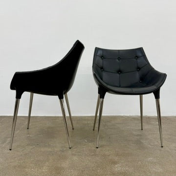 The Cassina Passion Side Chair by Cassina is a modern black upholstered chair with a curved backrest, button detailing, and four sleek metal legs inspired by the Passion design.