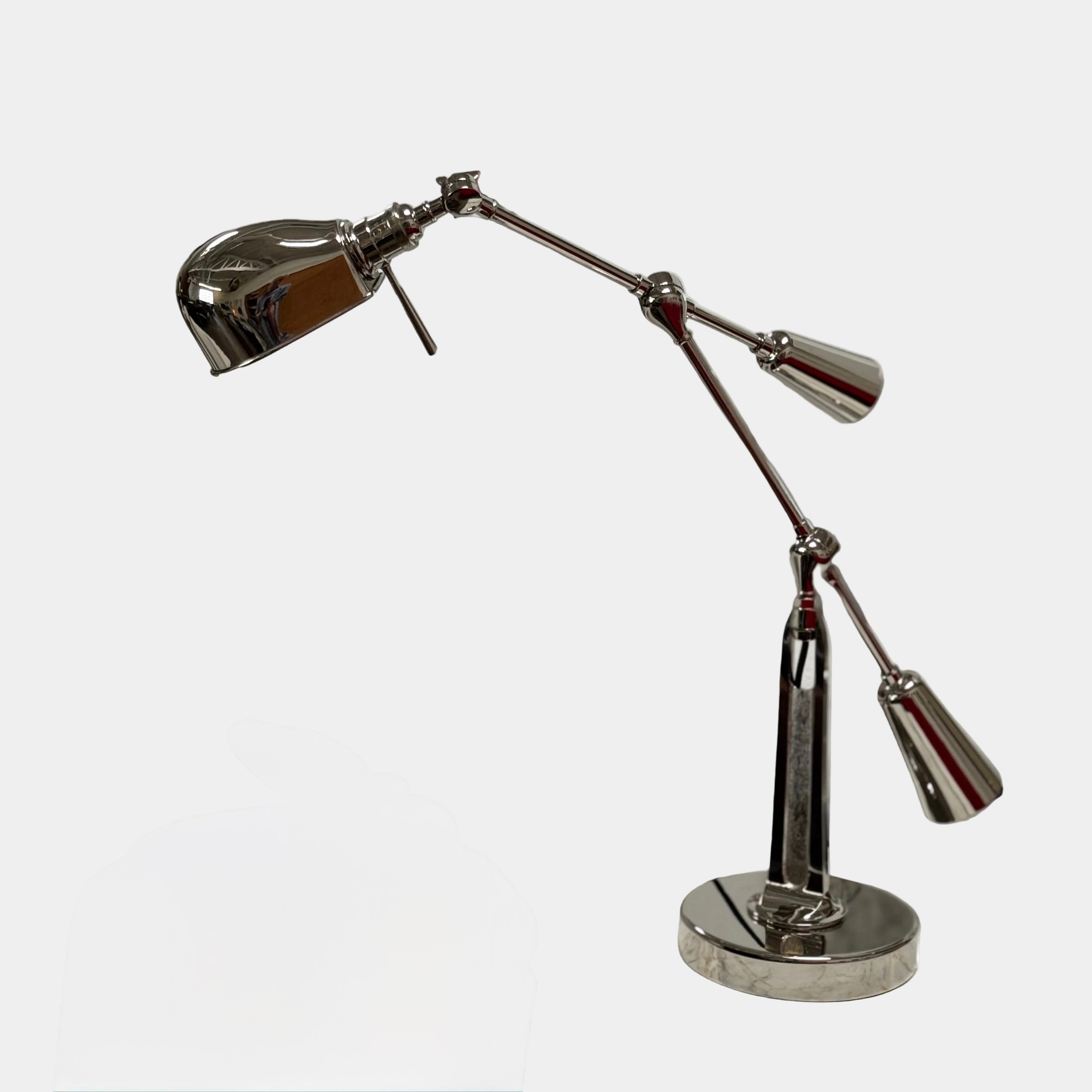 The Visual Comfort Ralph Lauren Signature Equilibrium table lamp by Visual Comfort Signature features a metallic, multi-jointed adjustable design with a round base, perfect for task lighting in modern interiors and shown on a white background.